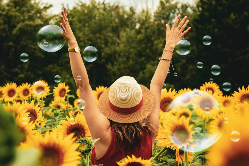a happy woman enjoying the sunflower field